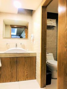La salle de bains est pourvue d'un lavabo et de toilettes. dans l'établissement Hotel & Suites Victoria, à San Luis Potosí