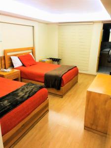 twee bedden in een hotelkamer met twee bedden bij Hotel & Suites Victoria in San Luis Potosí