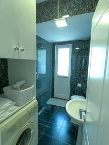 een badkamer met een wasmachine en een wastafel bij Roza's Studio Tirana Center in Tirana