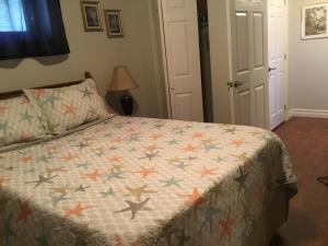 a bedroom with a bed with a quilt on it at BeachView Apartment in Port Hood