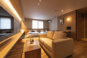 a living room with a couch and two beds at GRAND BASE Iolani in Beppu