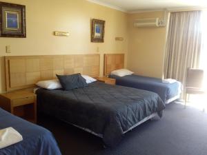 Habitación de hotel con 2 camas y ventana en Desert Sand Motor Inn en Broken Hill
