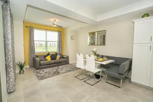 una sala de estar con una mesa y un sofá en Only 5 Miles from Disney! Free Water Park! 2 Bed, 2 Bath Condo, Sleeps 8, en Kissimmee