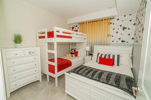 1 dormitorio con 2 literas con almohadas rojas en Only 5 Miles from Disney! Free Water Park! 2 Bed, 2 Bath Condo, Sleeps 8, en Kissimmee 26 fotos más
