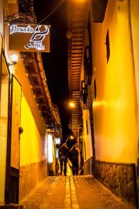 an alley with an elephant walking down a street at night at Posada SAQRA Cusco in Cusco