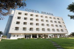 ein großes weißes Gebäude mit einem Schild drauf in der Unterkunft Grand Hotel Costa Brada in Gallipoli