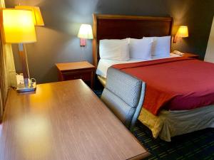 a hotel room with a bed and a table at Value Lodge - Gainesville in Gainesville