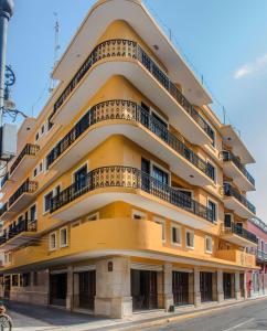 ein gelbes Gebäude mit Balkonen auf einer Straße in der Unterkunft Múcara hotel in Veracruz