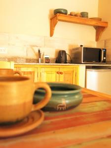 Casatilcara Cabañas في تيلكارا: مطبخ مع وعاء على طاولة خشبية