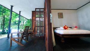 1 dormitorio con 1 cama, mesa y sillas en Waiwo Dive Resort Raja Ampat, en Rabia