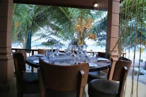 een tafel in een restaurant met een palmboom op de achtergrond bij JKAB Beach Resort in Trincomalee