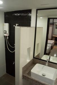 a bathroom with a sink and a mirror at The 168 Gallery Residence and Hotel in Chiang Mai