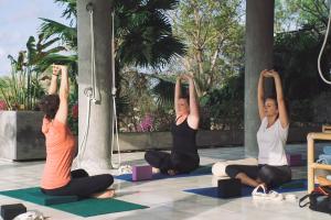 a group of women sitting in a yoga pose at Adila Bali in Uluwatu