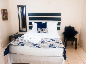 a bedroom with a large bed with blue and white pillows at Eventuality B&B New Kingston in Kingston
