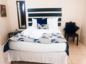 um quarto com uma cama com uma cabeceira azul e branca em Eventuality B&B New Kingston em Kingston