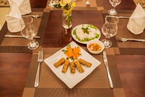 a wooden table with a plate of food on it at Salina Hotel Ninh Binh in Ninh Binh
