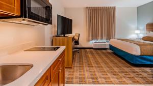 a hotel room with a bed and a kitchen with a sink at Best Western Ingleside Inn & Suites in Ingleside +19 photos