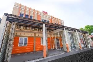 an orange building with an orange front with windows at OYO 1250 Unta Residence in Semarang