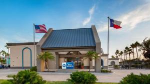 dos banderas volando frente a una gasolinera en Best Western Port Aransas, en Port Aransas