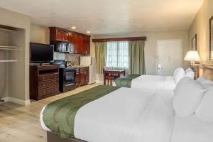 a hotel room with two beds and a flat screen tv at Quality Inn & Suites El Cajon San Diego East in El Cajon