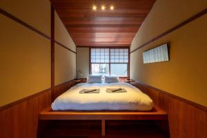 ein Schlafzimmer mit einem Bett in einem Zimmer mit einem Fenster in der Unterkunft UTAIMACHI in Kanazawa