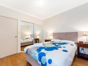 1 dormitorio con 1 cama grande y espejo en James On The Park, en Perth