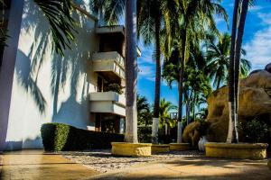 un edificio con palmeras delante en Ixtapa Palace en Ixtapa