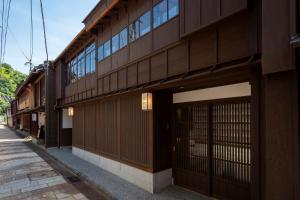 un bâtiment avec portes et fenêtres donnant sur une rue dans l'établissement UTAIMACHI, à Kanazawa