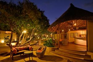 a patio with a gazebo and a couch and chairs at Dunes de Dovela eco-lodge in Chefe Chume