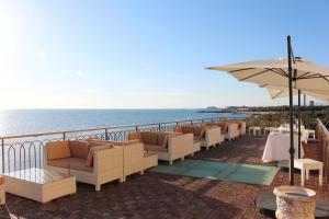 uma fila de cadeiras e mesas numa varanda com o oceano em Hotel Universal em Livorno