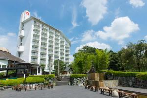 um edifício com bancos em frente a um edifício em Hotel Heritage em Kumagaya