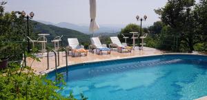 uma piscina com cadeiras, uma mesa e uma vista em #IoniaHouse Surrel Villa em Tirana