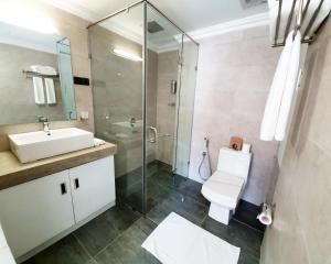 a bathroom with a shower and a toilet and a sink at Bed Station 210 in Kandy