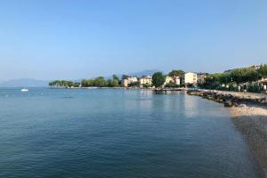 a large body of water with a beach and buildings at LA CHIARETTO SUITE in Bardolino