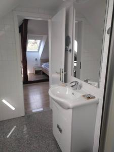 a white bathroom with a sink and a mirror at Hotel Katrca in Ljubljana
