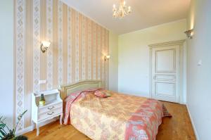 a bedroom with a bed and a chandelier at Ilo Apartamentai in Vilnius