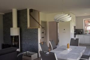 a dining room and living room with a table and chairs at Vila pod Černou horou in Rožnov pod Radhoštěm