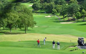 un grupo de hombres jugando al golf en un campo de golf en Hotel Heritage, en Kumagaya