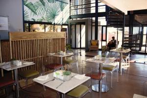 un restaurant avec des tables et des chaises dans un bâtiment dans l'établissement aha Kathu Hotel, à Kathu