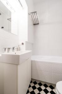 La salle de bains blanche est pourvue d'un lavabo et d'une baignoire. dans l'établissement Studio in heart of Warsaw II, à Varsovie