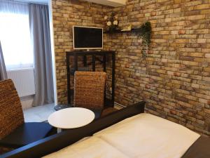 a living room with a brick wall and a tv at Hotel Kammerkrug in Bad Harzburg