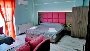 1 dormitorio con 1 cama grande y cabecero rosa en Hotel White Rose Beach, en Olympiakí Aktí