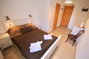 a bedroom with a bed with two white towels on it at Mi a Kő vendégház in Köveskál