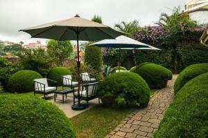 um pátio com uma mesa, cadeiras e um guarda-sol em Tsara Guest House em Fianarantsoa