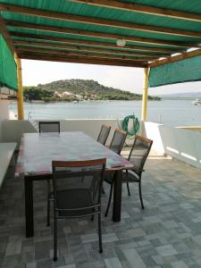 einen Tisch und Stühle auf dem Deck eines Bootes in der Unterkunft Apartment with sea view terrace in Betina