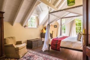 a bedroom with a canopy bed and a chair at Karen Gables in Nairobi