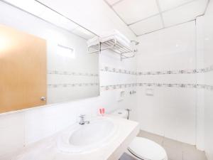 a white bathroom with a sink and a toilet at Super OYO 447 Comfort Hotel Meru in Klang