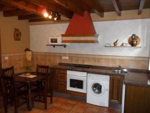 cocina con lavadora y mesa en Apartamentos Rurales Los Villares, en Colunga