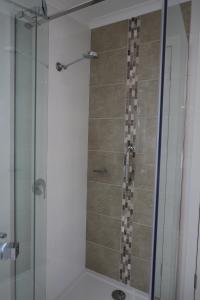 a shower in a bathroom with a glass door at Moonah Central Apartments in Hobart