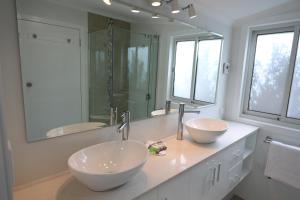 a bathroom with two sinks and a large mirror at Moonah Central Apartments in Hobart
